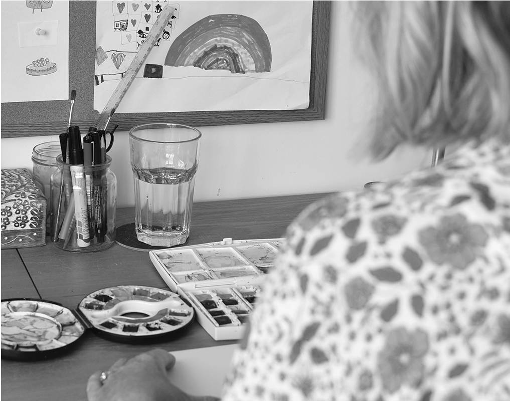 michelles desk with her watercolor paint brushes in a jar